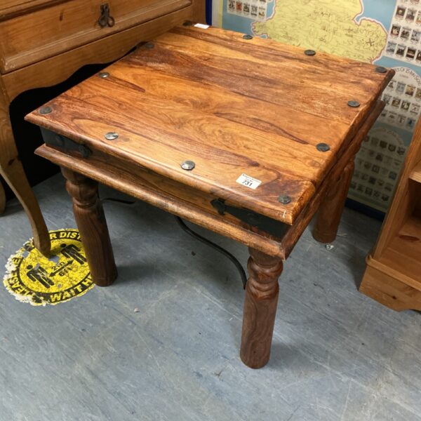 Rustic oak coffee table with square top and sturdy legs.