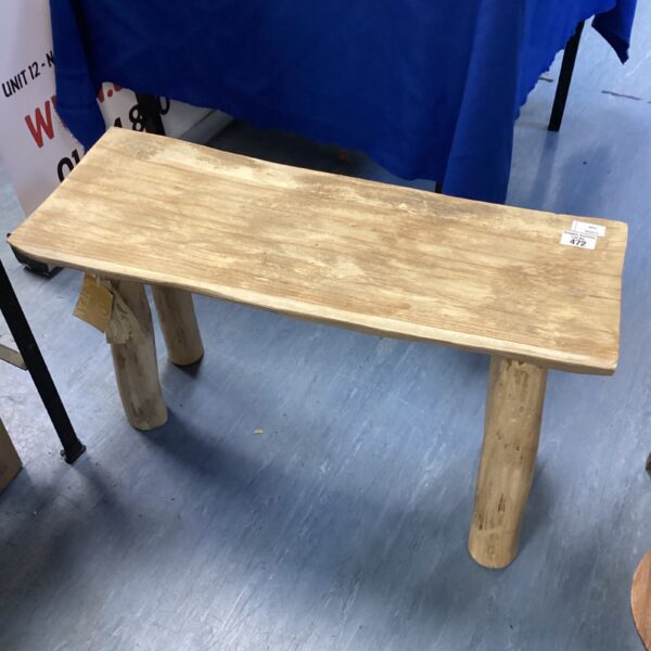Rustic teak stool with natural wood grain and organic form.