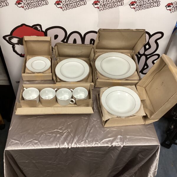 Stacked boxes of Sabichi dinnerware set, including plates and cups.