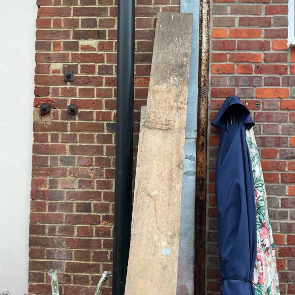 Reclaimed scaffolding planks leaning against a brick wall.