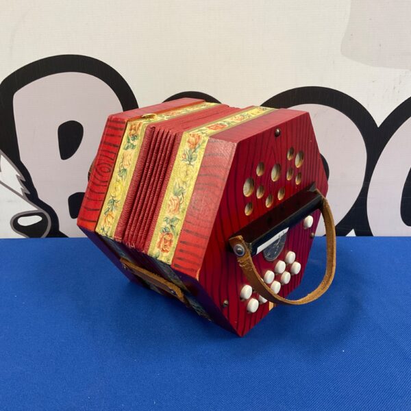 Vintage red Scholer accordion, a classic folk musical instrument.