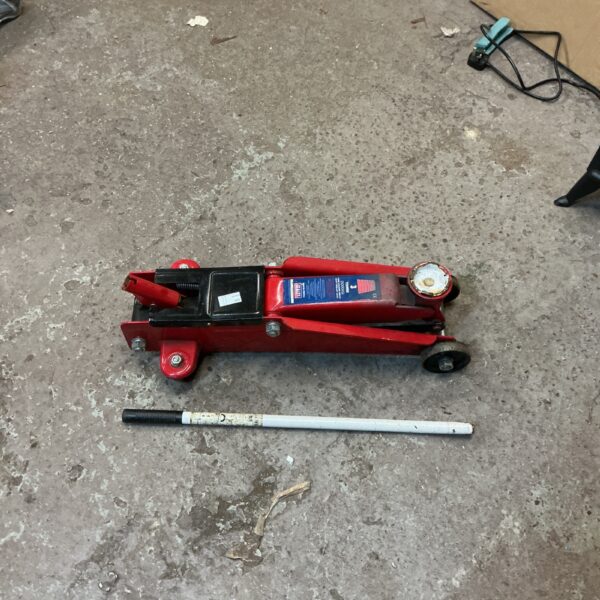 Sealey trolley jack with handle for automotive repairs.