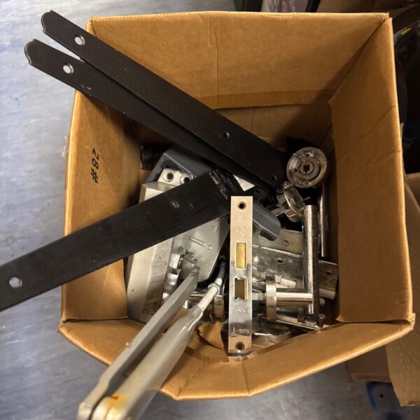 Mixed lot of shed hardware including door latches and metal brackets.