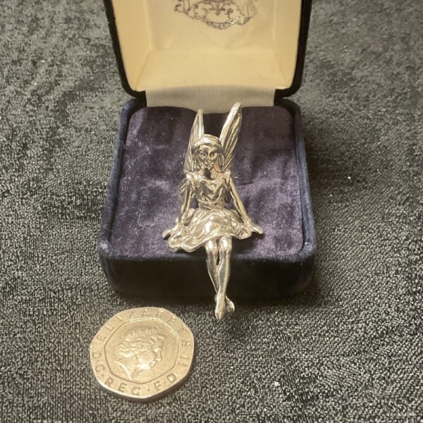 Vintage whitemetal shelf fairy figure on display.