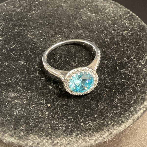 Silver ring with a vibrant blue topaz gemstone.