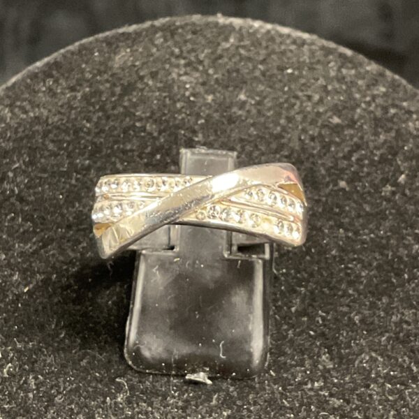 Silver crossover ring with white stones, size T.