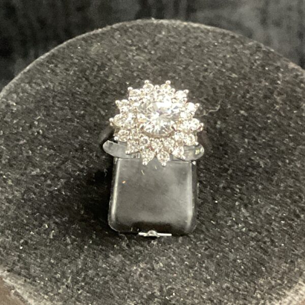 Silver CZ cluster ring on a display stand.
