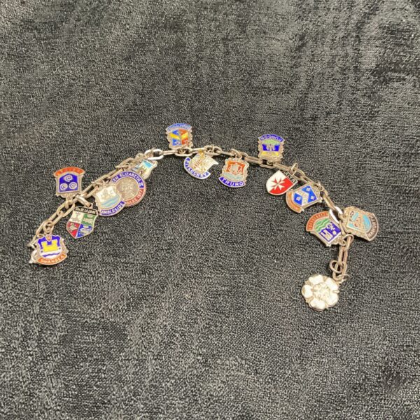 Vintage silver charm bracelet with colourful enamel shield charms.