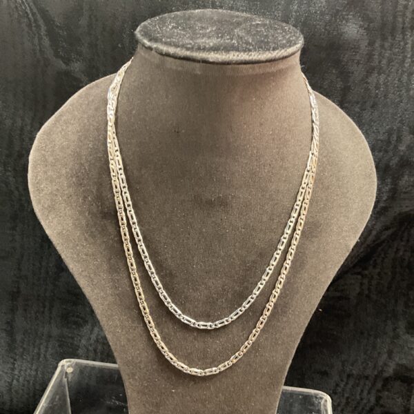 Two delicate 925 silver Figaro chain necklaces on display.