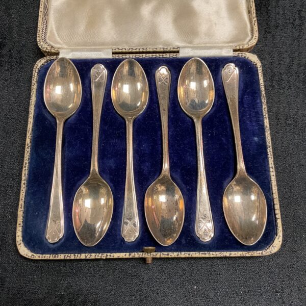 Cased set of six silver golf teaspoons in a navy case.