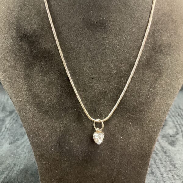 Silver heart pendant necklace on a snake chain.