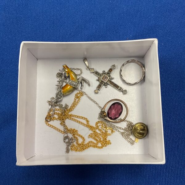 Vintage silver jewellery lot featuring a stag brooch and crucifix pendant.