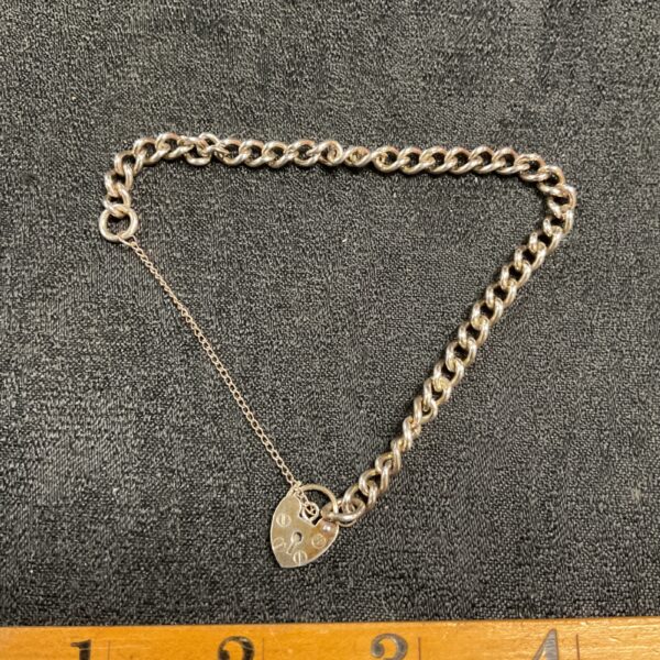 Close-up of a vintage silver padlock bracelet with a secure clasp.