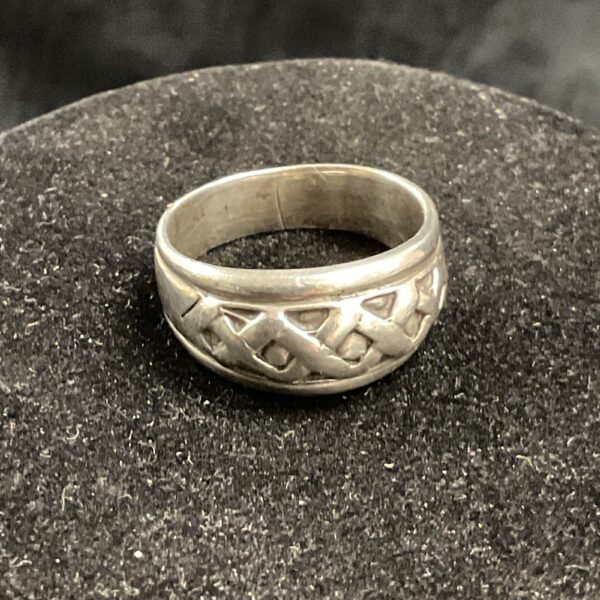 Close-up of a silver patterned ring, size Q.