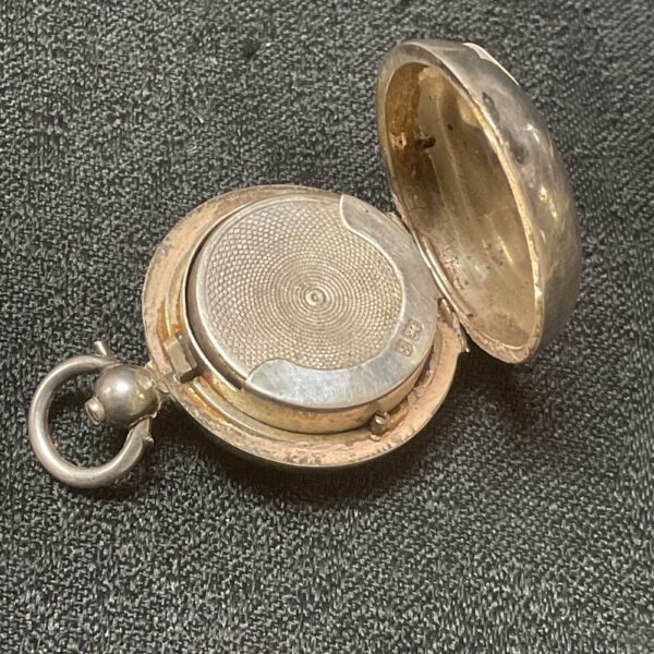 Open antique silver sovereign fob case, showing interior.