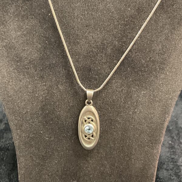 Silver pendant necklace with light blue topaz stone.