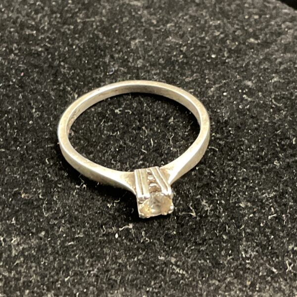 Silver ring with a white stone, size O.