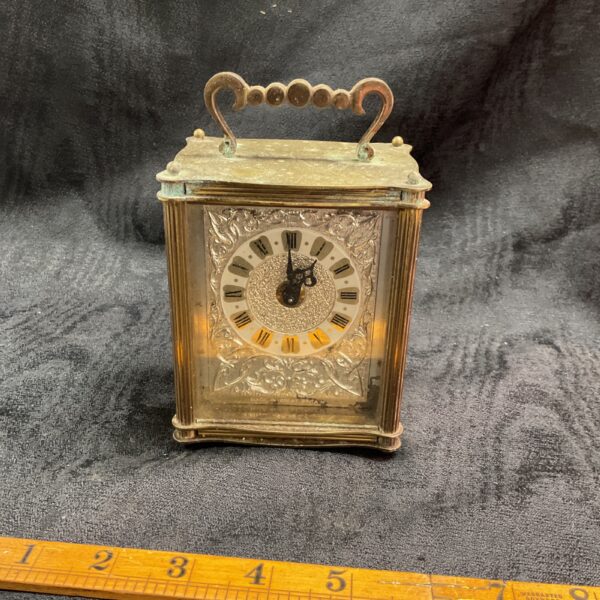 Antique Smiths carriage clock with brass case and white dial.