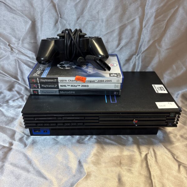 Sony PlayStation 2 console with games and controller for retro gaming.