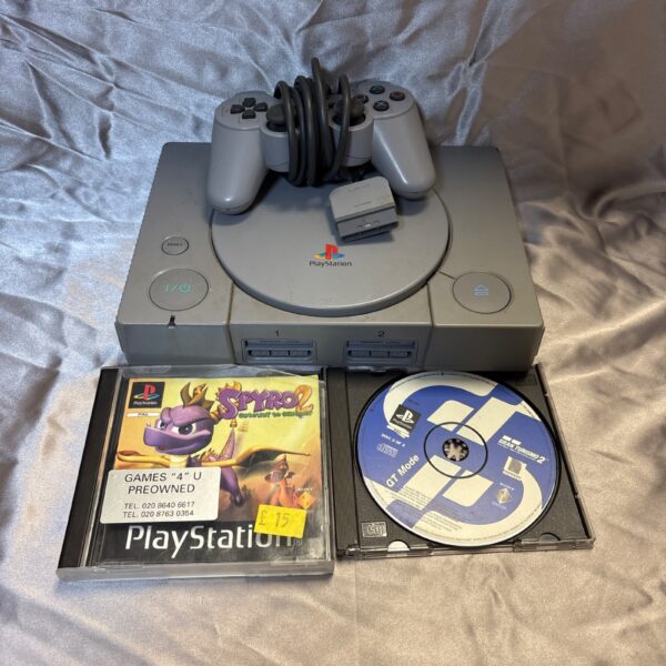 Sony PlayStation One console with games and controller for retro gaming.