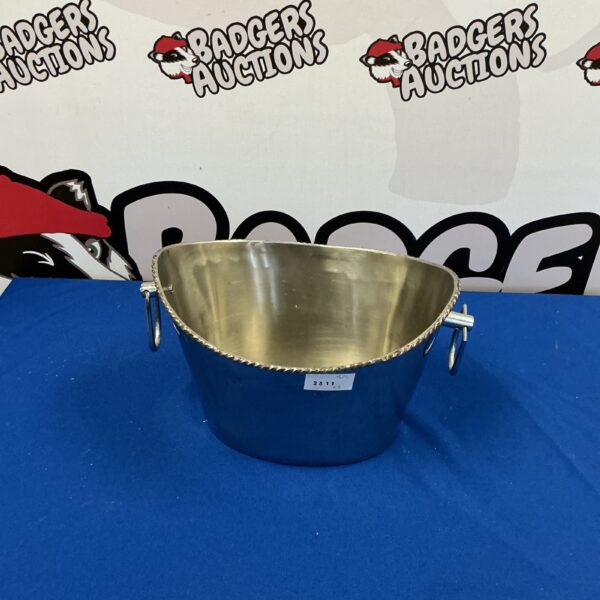 Polished stainless steel ice bucket with handles for serving drinks.