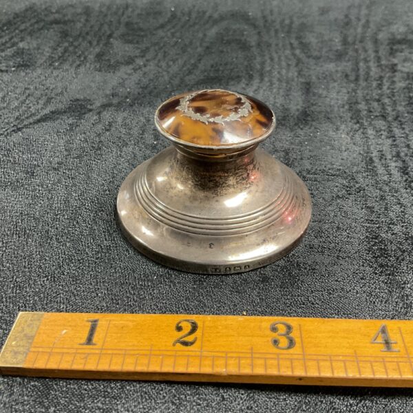 Antique sterling silver inkwell with tortoise shell lid on ruler.