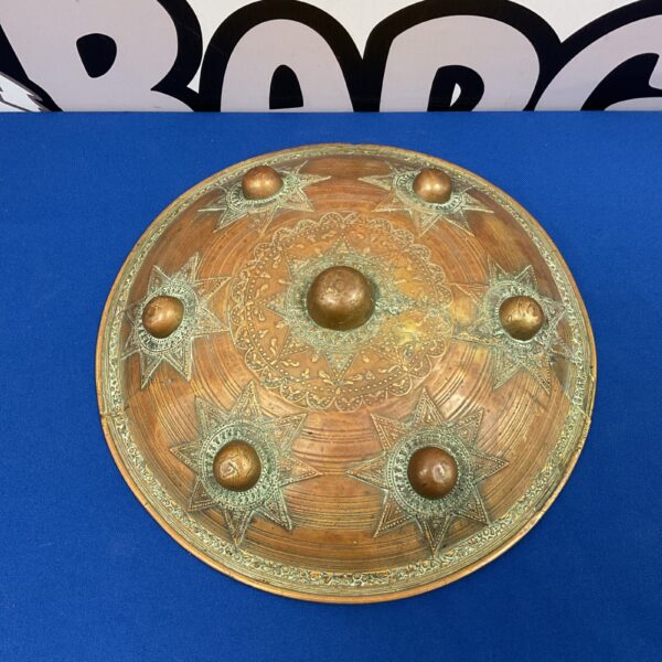 Antique Sumatran brass shield with intricate embossed detailing.