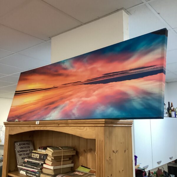 Large sunset canvas print with bold colours depicting a seascape.