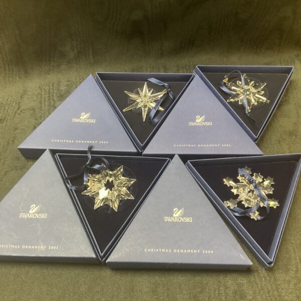 Four Swarovski crystal Christmas ornaments in original boxes.