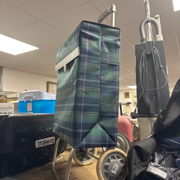 Tartan shopping trolley with four wheels for easy portability.