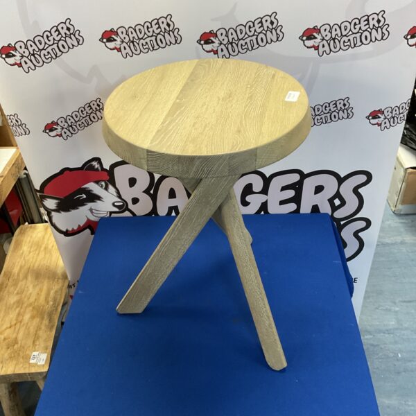 Small three-legged wooden table with a rustic finish.