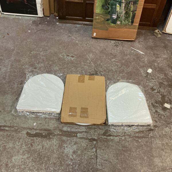 Unopened lot of three new toilet seats in original packaging.
