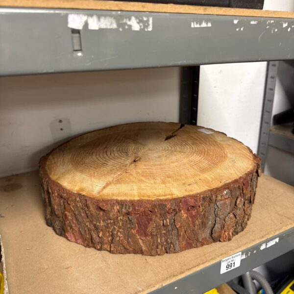 Rustic tree trunk slice, potentially redwood, with visible growth rings.