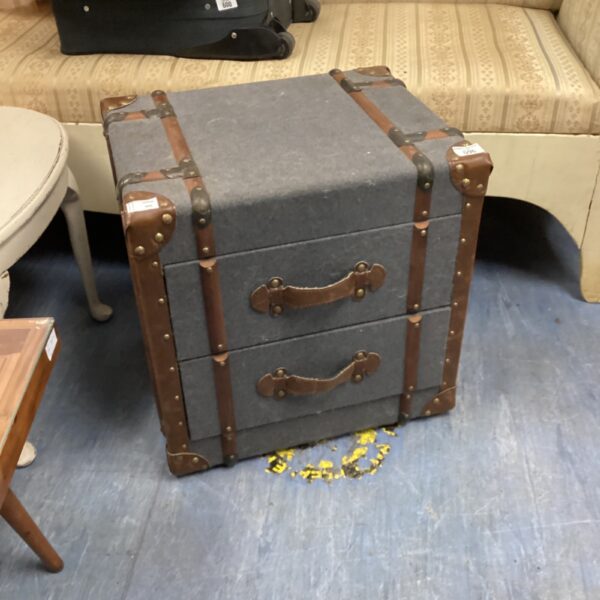 Front view of upholstered trunk chest with two drawers.