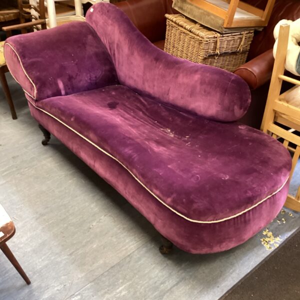 Antique Victorian chaise lounge upholstered in purple fabric.