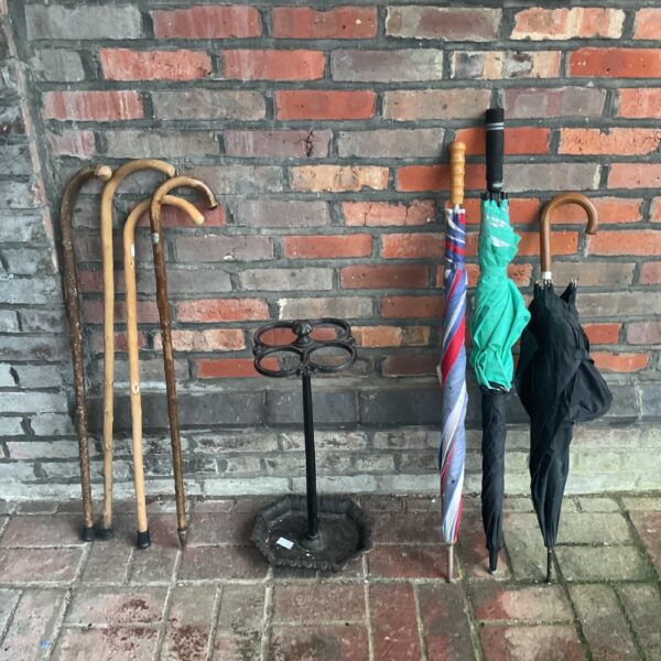 Antique Victorian stick stand with walking sticks and umbrellas.