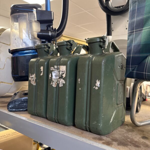 Three vintage 5L metal Jerry cans with faded markings.
