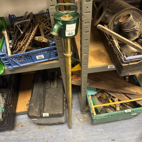 Side view of a vintage metal barrel pump for water extraction.