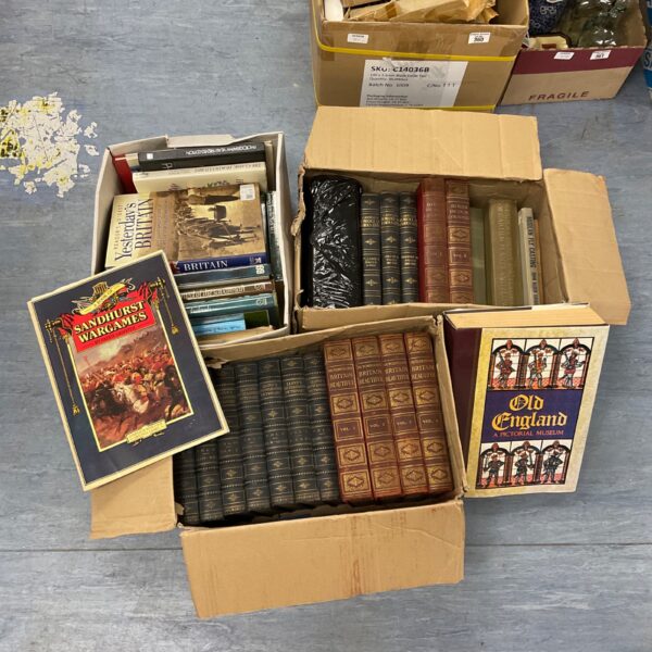Stack of boxes filled with a vintage book collection.