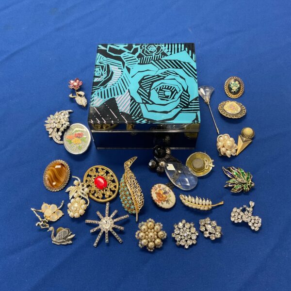 Vintage brooch collection in a Zand la Rhodes mirrored jewellery box.