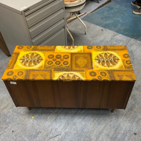 Front view of a vintage cedar chest with geometric pattern.