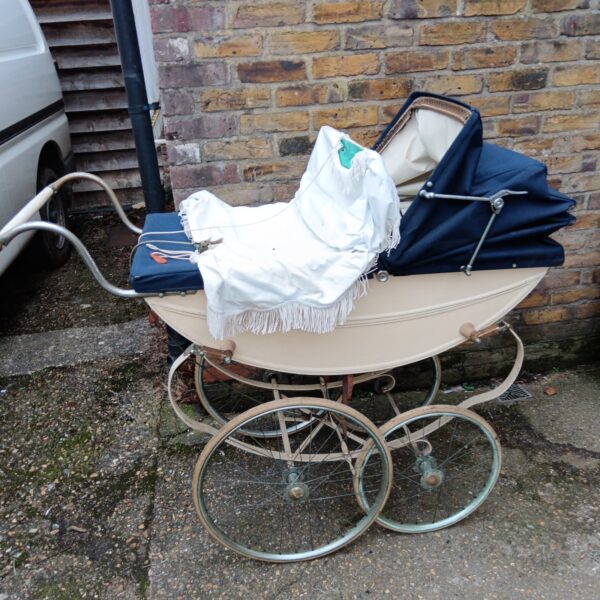 Vintage Churchill pram with spoked wheels and navy interior.