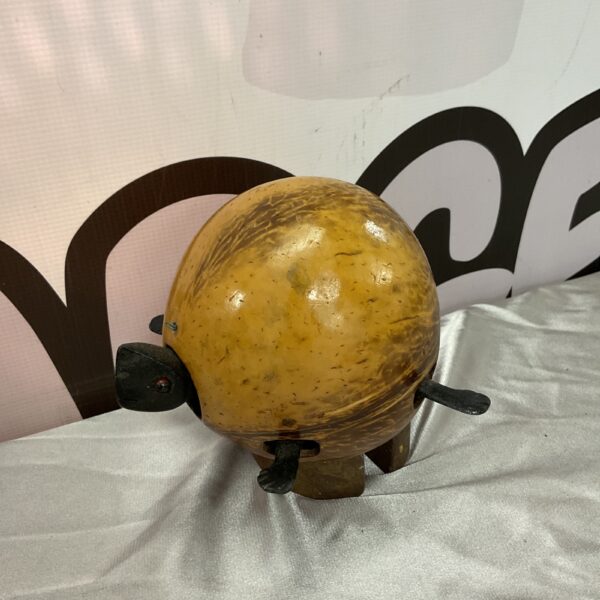 Vintage coconut shell turtle sculpture with metal legs.