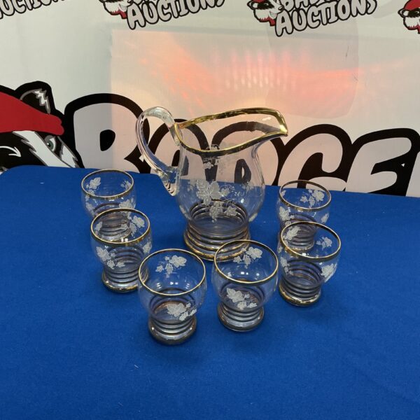 Vintage cut glass pitcher set with six tumblers displayed.