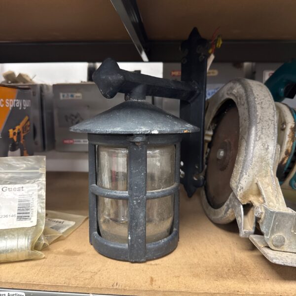 Vintage electric wall lantern with metal cage and glass panel.