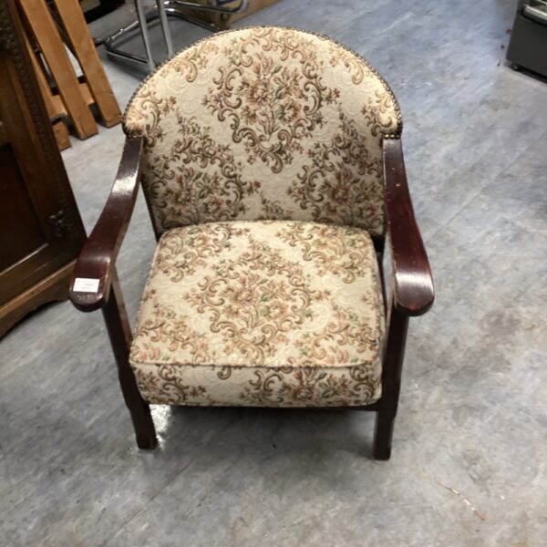 Vintage floral armchair with patterned upholstery and wooden frame.