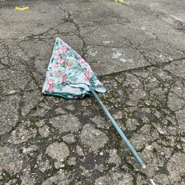 Vintage floral patio parasol in a garden setting.