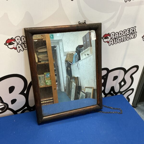 Vintage framed mirror with wooden frame for wall decor.