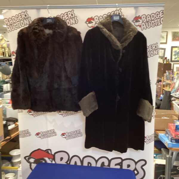 Pair of vintage dark fur coats on display.