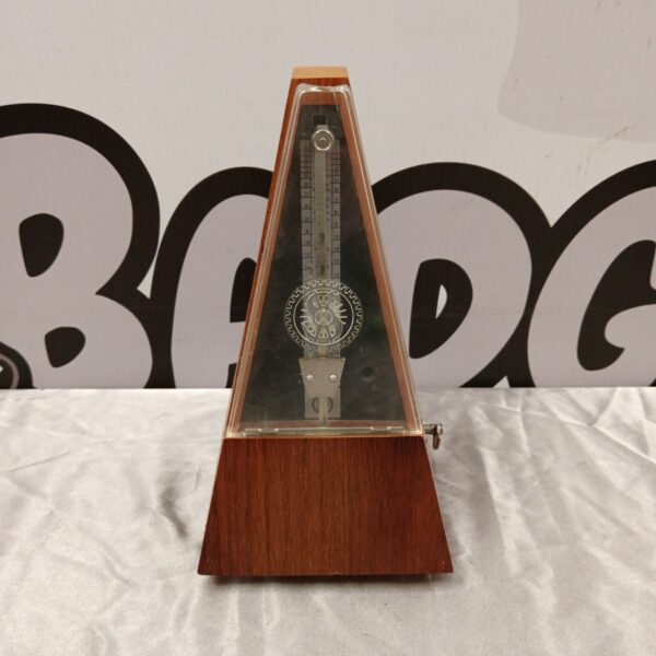 Vintage German metronome with wooden casing and pendulum.